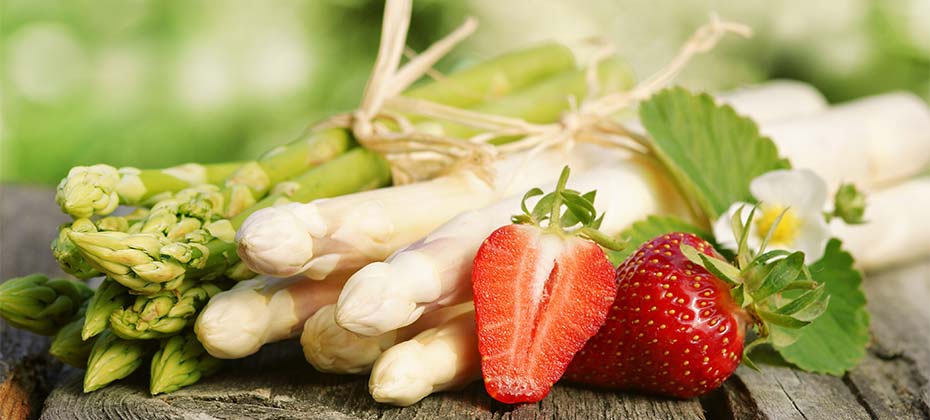 Frischer grüner und weißer Spargel und Erdbeeren